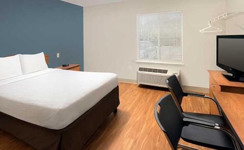 een slaapkamer met een bed, een bureau en een televisie bij WoodSpring Suites Clarksville Ft. Campbell in Clarksville