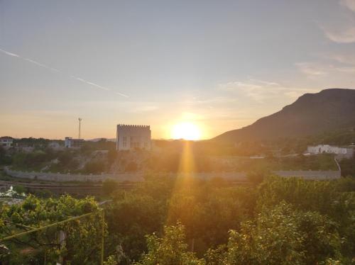 een uitzicht op de zonsondergang boven een stad bij Apartments Pravica in Trebinje