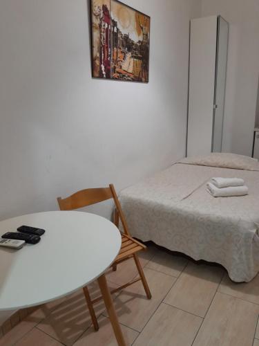 um pequeno quarto com uma cama, uma mesa e uma cadeira em Palma em Roma