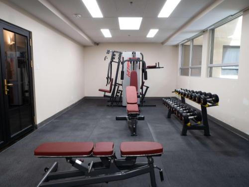 une salle de sport avec des haltères et des tapis de course dans l'établissement Hotel Montreal Metropolitan, BW Signature Collection, à Montréal