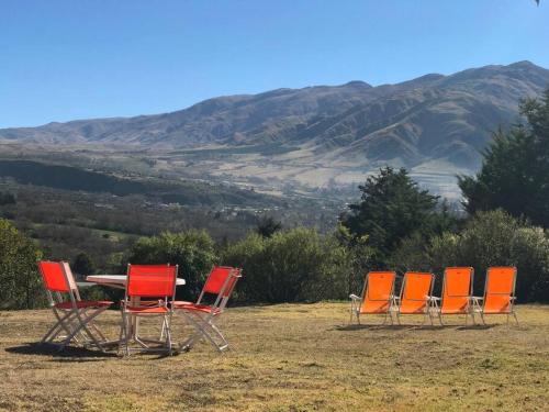 un gruppo di sedie intorno a un tavolo con montagne sullo sfondo di Lindísima Casa en Tafí del Valle a Tafí del Valle