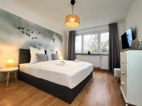 a bedroom with a bed with birds on the wall at BohnApartments Juwel am See, mitten in der Natur - gratis Parkplatz - Kamin - WLAN - Nähe Erfurt in Kranichfeld