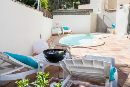 a patio with a table and chairs and a pool at VILLA WINE & BEACH Design and Luxury in Cala Crancs in Salou