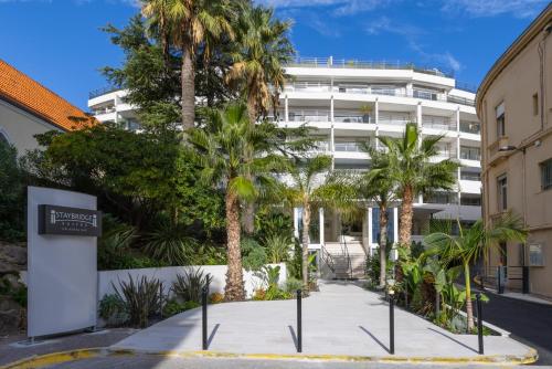 een straat met palmbomen voor een gebouw bij Staybridge Suites - Cannes Centre, an IHG Hotel in Cannes