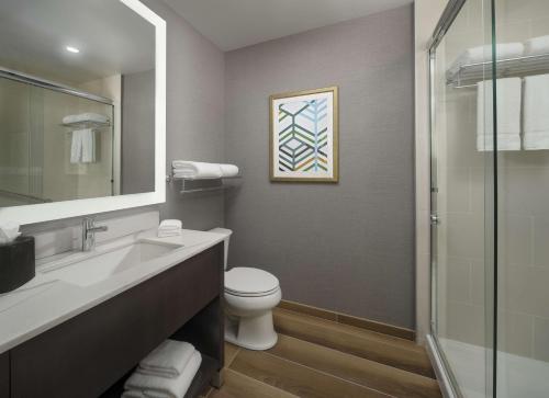 a bathroom with a toilet and a sink and a shower at Hyatt House LAX Century Blvd in Los Angeles