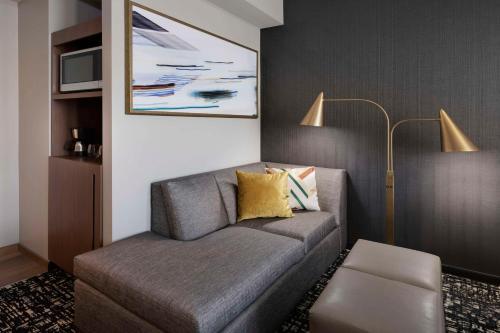 a living room with a couch and a lamp at Hyatt House LAX Century Blvd in Los Angeles