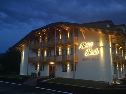 un edificio con un cartello sul lato di esso di notte di B&B Hotel Heidi a Dobbiaco