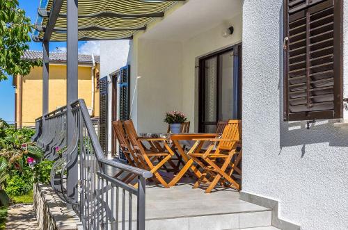 une terrasse avec des chaises et une table sur une maison dans l'établissement Neu renovierte Ferienwohnung mit Klima, WLAN, Terrasse und Grill, à Pula