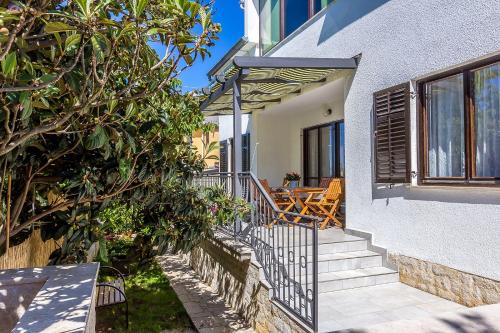 une maison avec des escaliers menant à un balcon. dans l'établissement Neu renovierte Ferienwohnung mit Klima, WLAN, Terrasse und Grill, à Pula