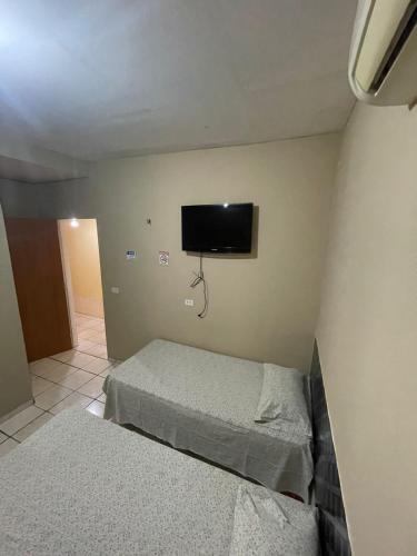 een slaapkamer met 2 bedden en een flatscreen-tv bij Hotel Horizonte in Teresina