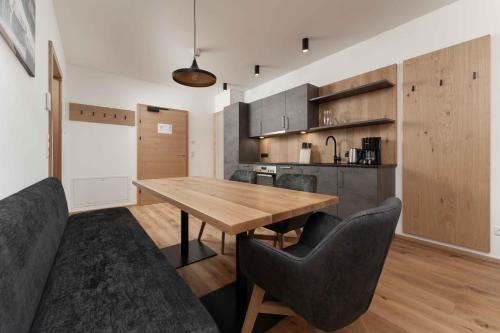 a kitchen and dining room with a wooden table and chairs at A CASA Serenity in Serfaus