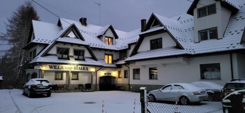 a large white house with snow on the roof at Willa Nad Białką in Białka Tatrzanska