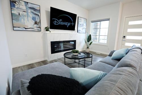 een woonkamer met een bank en een open haard bij Three King Beds,Central A/C,Fireplace,Park,Disney+ in Edmonton