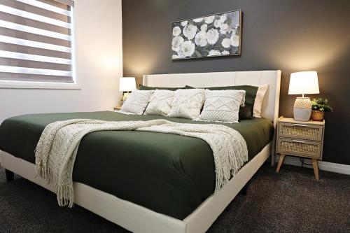 een slaapkamer met een groot bed en een groen dekbed bij Three King Beds,Central A/C,Fireplace,Park,Disney+ in Edmonton