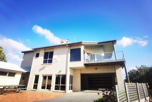 ein großes weißes Gebäude mit Balkon darüber in der Unterkunft Freestanding house with ocean view in Port Campbell