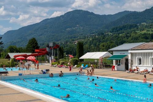 een groot zwembad met veel mensen erin bij Charmant mobilhome à 2 pas remontés ski Samoëns in Samoëns