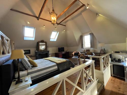 een slaapkamer met een groot bed op zolder bij Plompeblad Suite Giethoorn in Giethoorn