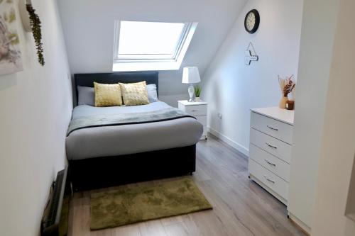 una camera con letto, cassettiera e finestra di Luxury 2 Bedroom Apartment Southsea - Free Parking a Portsmouth