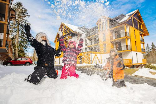 un grupo de personas jugando en la nieve en Rezydencja AQUA, en Szklarska Poręba