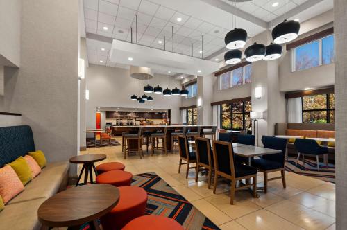 um restaurante com mesas e cadeiras e um bar em Hampton Inn & Suites Fort Belvoir Alexandria South em Alexandria