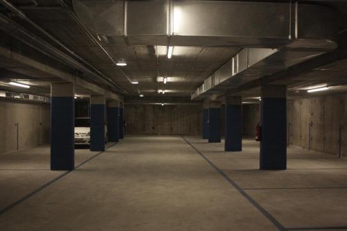 an empty parking lot with columns in a parking garage at OD'A Apartaments in Roses