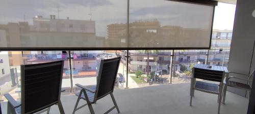 two chairs on a balcony with a view of a city at OD'A Apartaments in Roses