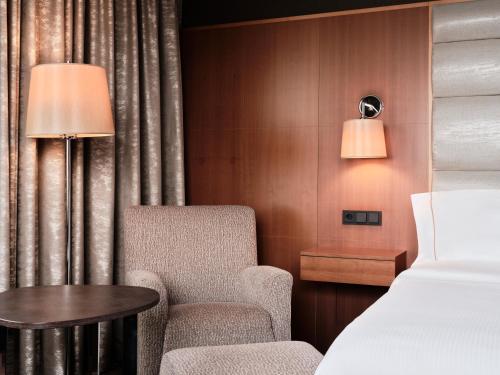 una camera con letto, sedia e tavolo di The Westin Warsaw a Varsavia