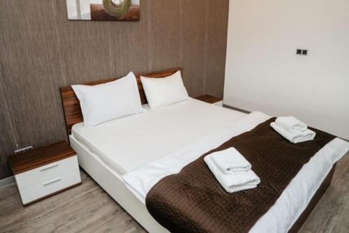 a bedroom with a large bed with two towels on it at Silver Mountain, Poiana Brasov - Forest Crib in Braşov