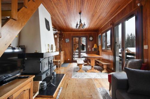 The Historic Chalet Les Allognes Mont-Blanc views في لي أوش: غرفة معيشة مع موقد وتلفزيون