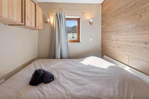 a bedroom with a white bed with a window at Smartstay Altineige - Val Thorens in Val Thorens