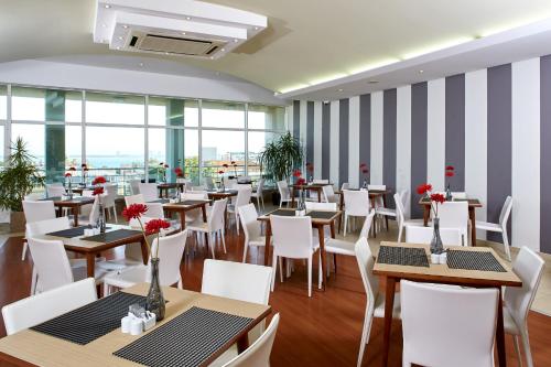 a restaurant with tables and chairs and windows at Luna Esperanca Centro Hotel in Setúbal