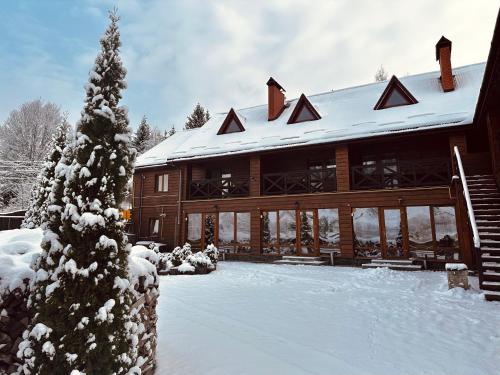 Casa de madera grande con techo cubierto de nieve en Chalet Filvarok, en Slavske