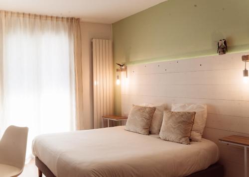 - une chambre avec un grand lit blanc et une fenêtre dans l'établissement Hôtel Le Rivage vue sur mer - Châtelaillon-plage, à Châtelaillon-Plage