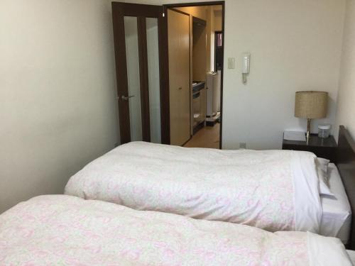 Uma cama ou camas num quarto em Business Inn Grandeur Fuchu