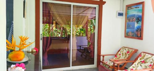 Cette chambre dispose d'une porte coulissante en verre donnant sur une terrasse. dans l'établissement Dan Zoranz Self Catering Guest House, à La Digue