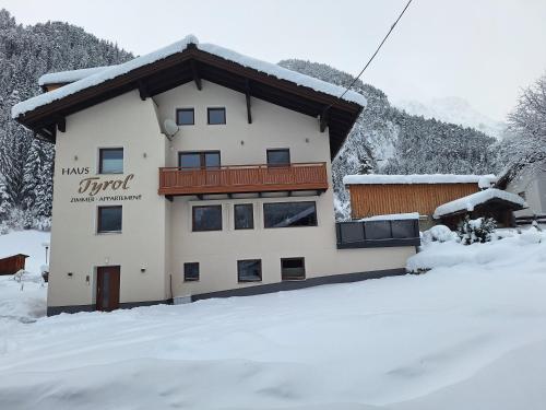 Appartements Tyrol في بيتنيو آم أرلبرغ: مبنى فيه ثلج على الارض امامه