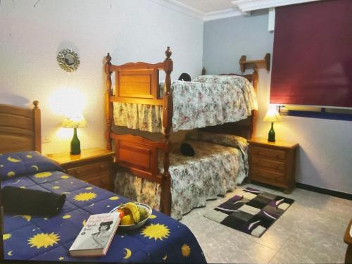 um quarto com 2 beliches e uma tigela de fruta numa mesa em Punta Umbría relax em Punta Umbría