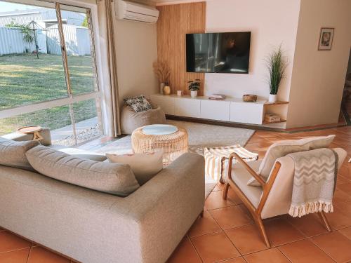 a living room with a couch and a tv at BEACH 400m, Big Yard, Playroom, Perfect for Families, Couples, Digital Nomads in Mandurah