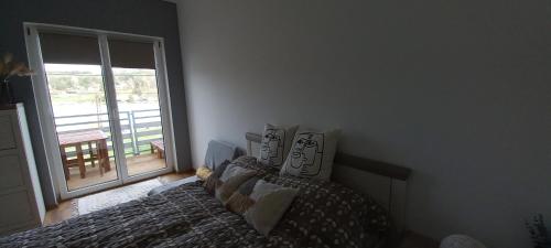 a bedroom with a bed and a large window at Onix-Vital Apartman Orfű in Orfű