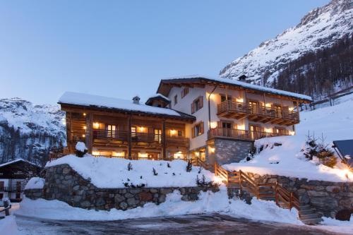 un edificio en la nieve con luces encendidas en Ellex Eco Hotel, en Gressoney-la-Trinité