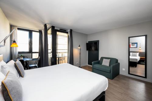 Staycity Aparthotels Marseille Centre Vieux Port في مارسيليا: غرفة نوم بسرير ابيض كبير وكرسي