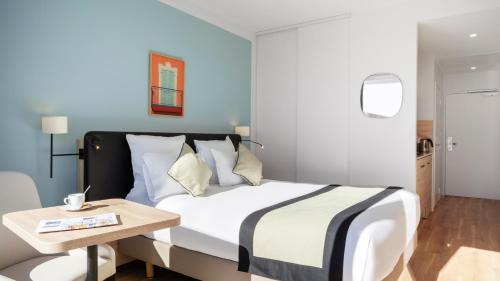 une chambre d'hôtel avec un lit et une table dans l'établissement Residhome Nice Aéroport, à Nice