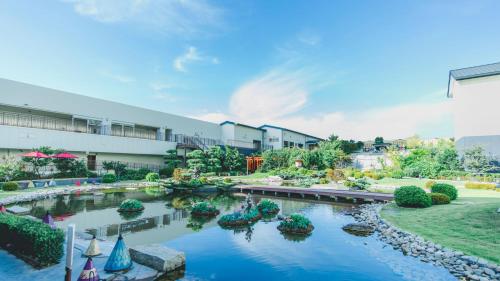 un jardin avec un étang en face d'un bâtiment dans l'établissement Art Hotel Osaka Bay Tower, à Osaka