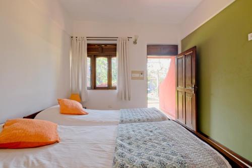 - une chambre avec 2 lits et des oreillers orange dans l'établissement Skylark Resort, à Colva