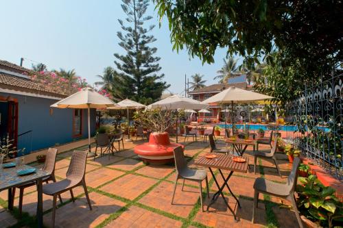 une terrasse avec des tables et des chaises ainsi qu'une piscine dans l'établissement Skylark Resort, à Colva