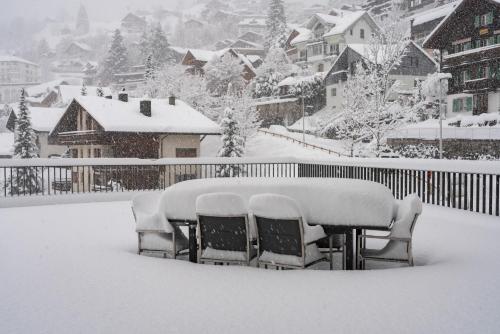 una mesa cubierta de nieve en un patio en Swiss Hotel Apartments - Engelberg, en Engelberg