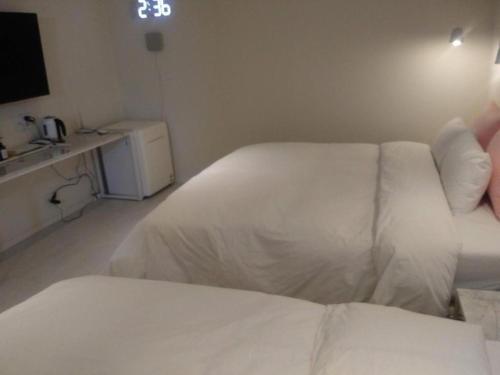 1 dormitorio con 1 cama blanca y cocina en 해운대 모모쥬스호텔 부산 MoMo Juice Busan Haeundae, en Busan