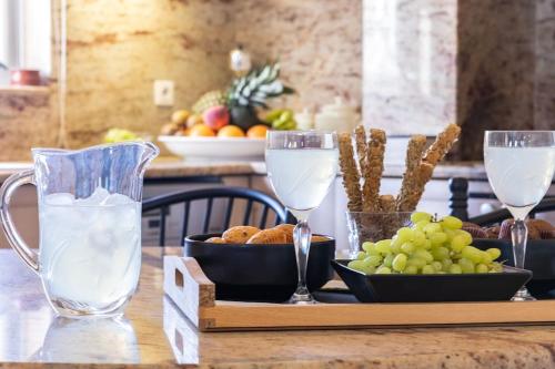 une table avec des verres de lait et un bol de raisins dans l'établissement Selenophile Villa, à Monolithos