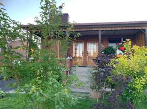 uma casa com um monte de plantas à frente dela em Havre chez Guylaine em Laval