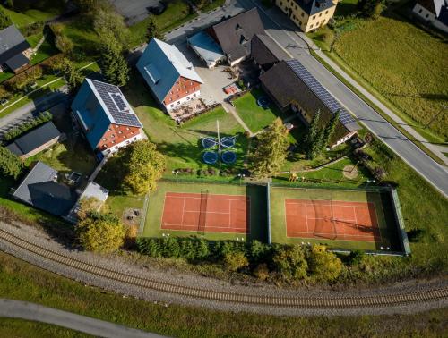 - une vue sur une maison dotée d'un court de tennis dans l'établissement Horský Hotel Skiland, à Ostružná